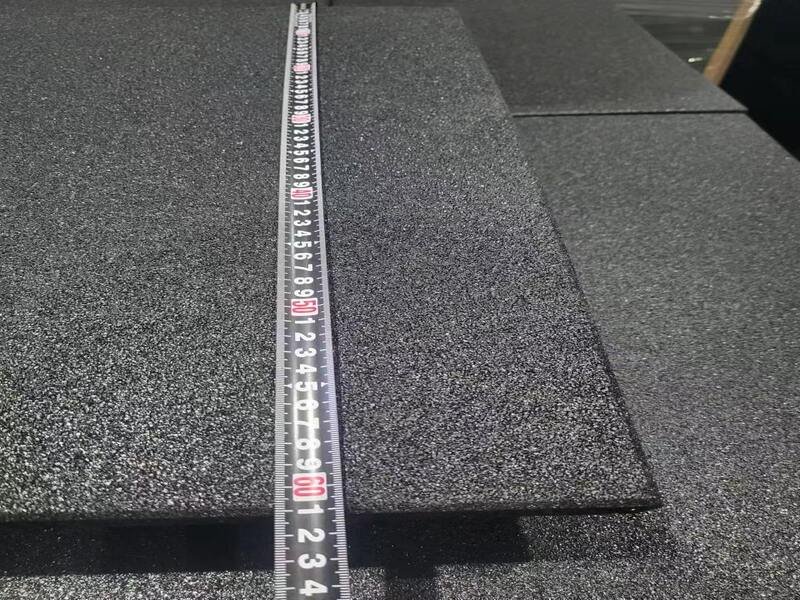 لقطة واسعة لصالة رياضية تجارية بأرضية مطاطية سوداء في جميع أنحاء منطقة رفع الأثقال.